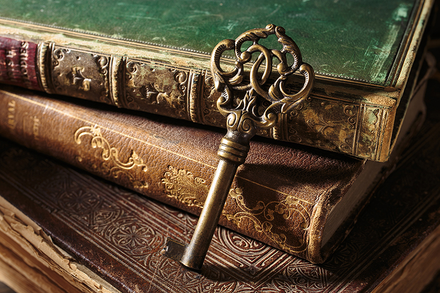 An elegant key leaning against a stack of priceless manuscripts symbolizing traditional knowledge and values augmented by modern technologies.