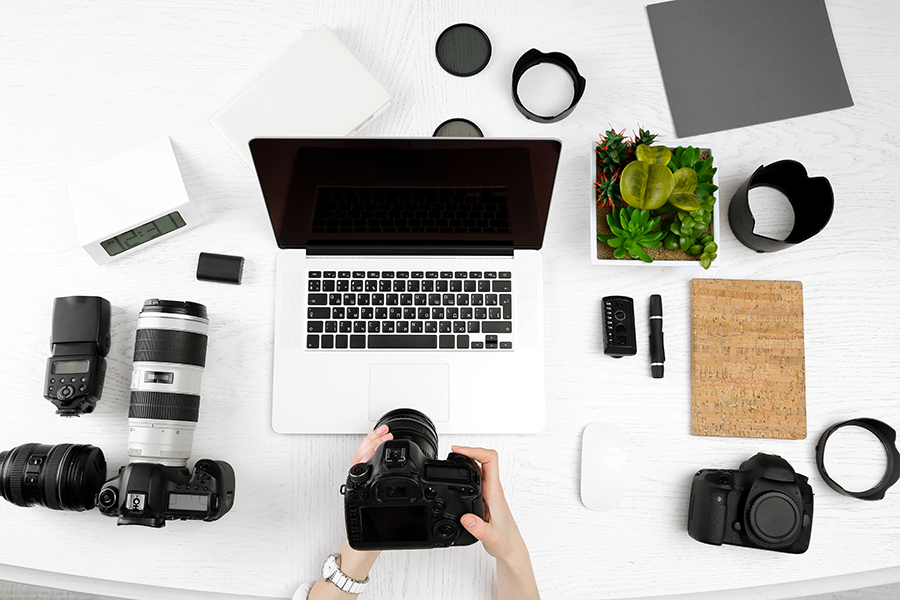 Professional camera equipment and laptop with photo editing software.